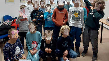 Kinder mit selbstgebastelten Masken im Grünen Klassenzimmer im LVwA