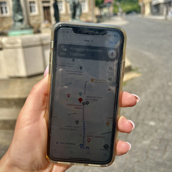 Handy in der Hand mit Hintergrund einer Altstadt
