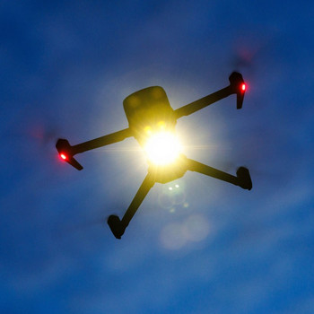 Drohne am Himmel, die von der Sonnen beleuchtet wird